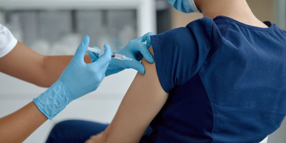 woman doctor holding syringe making covid 19 vaccination injection dose in shoulder of female patient. Flu influenza vaccine clinical trials concept, corona virus treatment side effect, inoculation