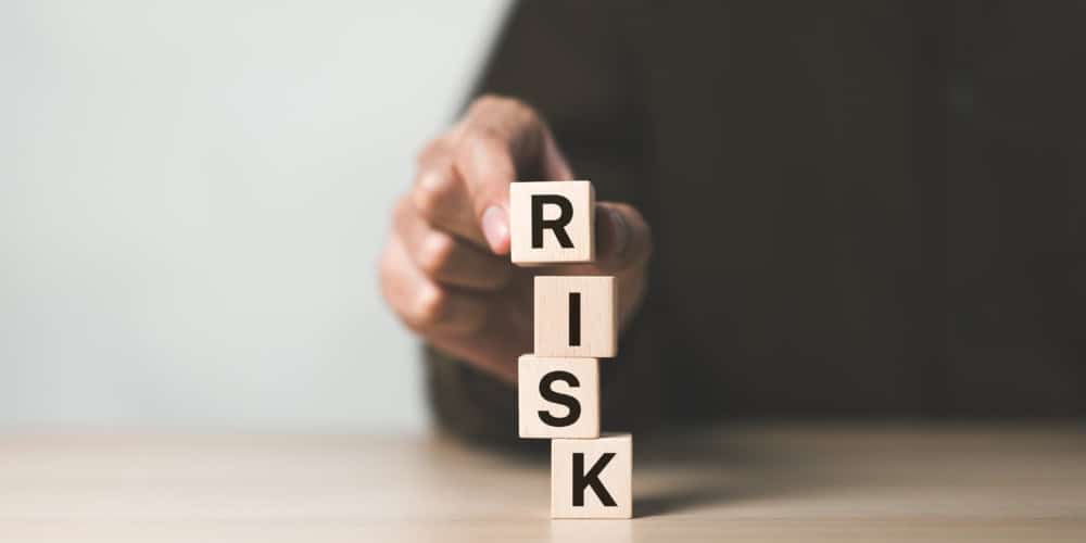 Risk management concept. Businessman hand put risk word on wooden block cube for financial banking analysis and business management. money risk assessment, Reducing project risk, finance, insurance,